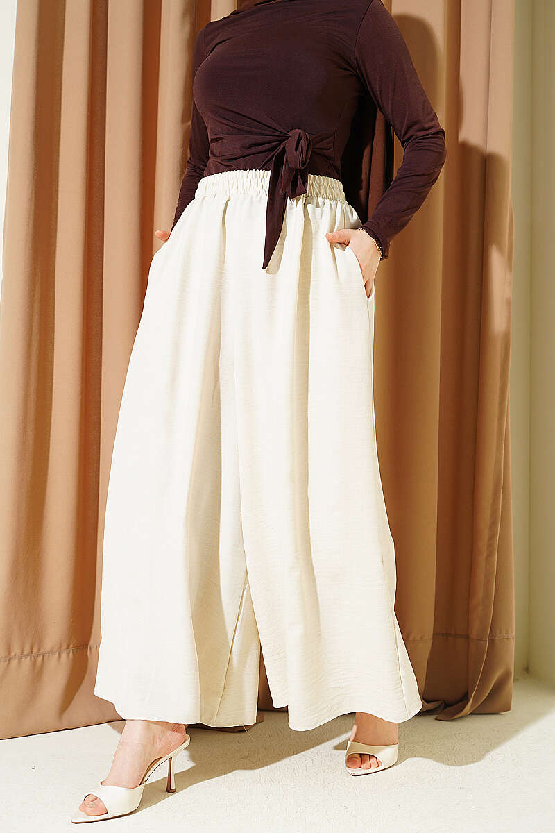 https://cdn.pazarium.com.tr/beli-lastikli-oversize-pacali-pantolon-bej-763876-18-B.jpg