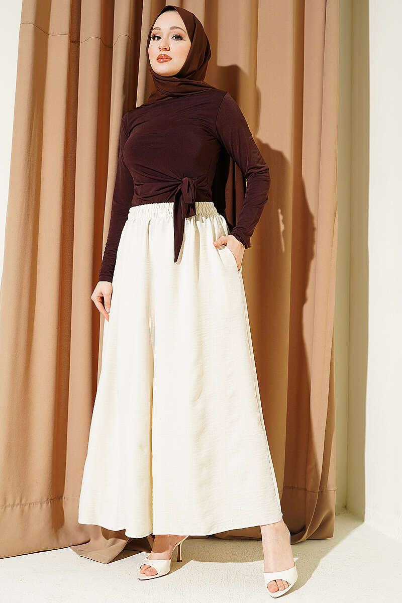 https://cdn.pazarium.com.tr/beli-lastikli-oversize-pacali-pantolon-bej-763879-18-B.jpg