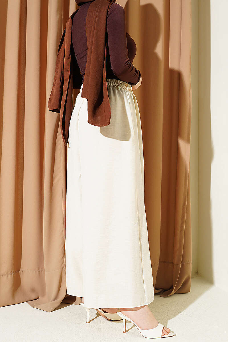 https://cdn.pazarium.com.tr/beli-lastikli-oversize-pacali-pantolon-bej-763881-18-B.jpg