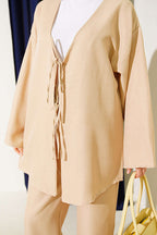 https://cdn.pazarium.com.tr/onu-ip-bagcikli-kimono-ikili-takim-bej-810649-20-B.jpg