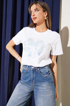 https://cdn.pazarium.com.tr/simli-cicek-baskili-t-shirt-beyaz-767231-18-B.jpg