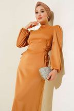 https://cdn.pazarium.com.tr/yanlari-ip-detayli-saten-elbise-camel-533164-12-B.jpg